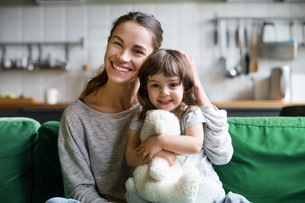 Portrait of happy family single mother and kid daughter embracing